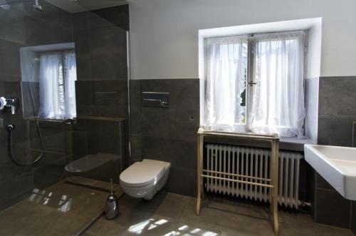 baño con aseo y lavabo y ventana en Ferienhaus Alpenbichl - a74010 en Krün