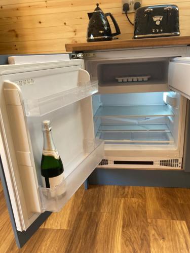 an open refrigerator with a bottle of wine in it at Laity's Lodge in Penzance