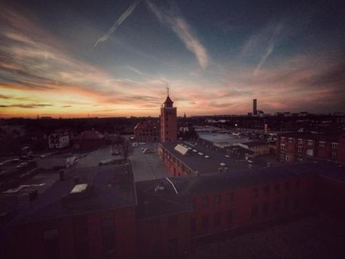 a view of a city at sunset with a building at Sunset Apartament in Wrocław