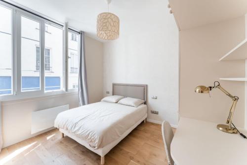 une chambre blanche avec un lit et une fenêtre dans l'établissement Luxury home in heart of PARIS!Opera/Eurostar 4pers, à Paris
