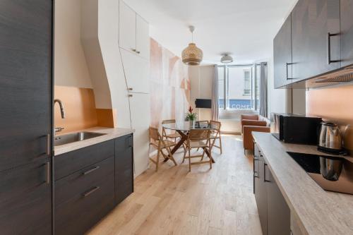 eine Küche mit einem Waschbecken und einem Tisch darin in der Unterkunft Luxury home in heart of PARIS!Opera/Eurostar 4pers in Paris