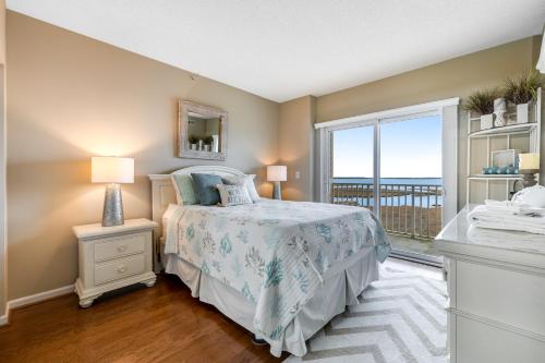 um quarto com uma cama e uma grande janela em Playa Flamingo #302 em Ocean City