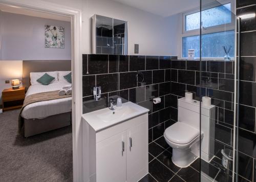 a bathroom with a toilet and a sink and a bed at Royal Lion Hotel in Tenby