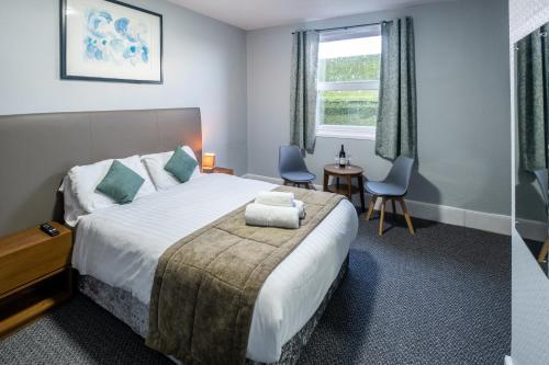 a hotel room with a bed and a table and chairs at Royal Lion Hotel in Tenby