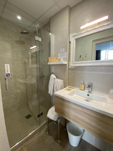 a bathroom with a sink and a shower at Grand Hôtel De La Poste in Salon-de-Provence