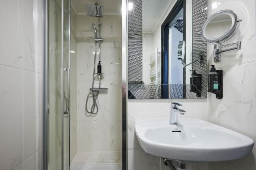 a white bathroom with a sink and a mirror at Hotel des Congrès et Festivals in Cannes