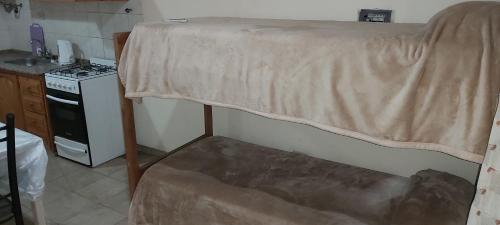 Una cama en una cocina con una sábana. en El Fortinero Departamento 2 en San Rafael