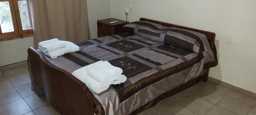 1 dormitorio con 1 cama con toallas en El Fortinero Departamento 2 en San Rafael
