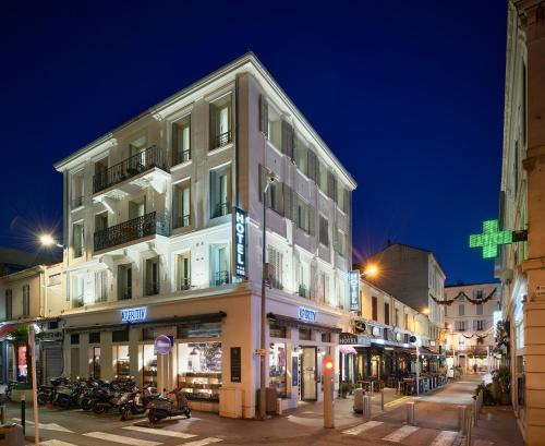 un edificio alto en una calle de la ciudad por la noche en Apparthotel des Congrès et Festivals, en Cannes