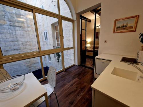 d'une cuisine avec un évier, une table et une fenêtre. dans l'établissement Grand House of Character Valletta, à Il-Furjana