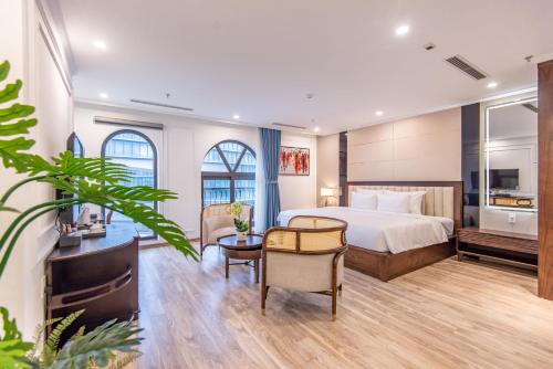 Cette chambre comprend un lit et un bureau. dans l'établissement Reyna Luxury Hotel, à Hanoï