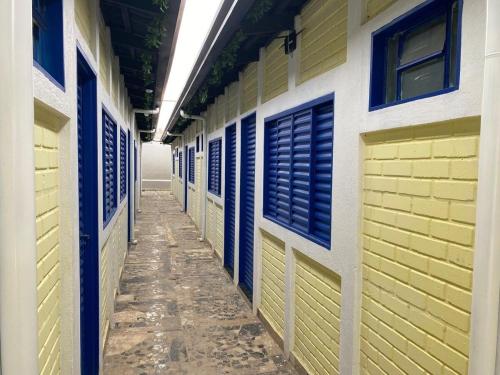 an empty hallway of a building with blue and yellow doors at GYN SUITES - SUITES EM GOIÂNIA GO in Goiânia