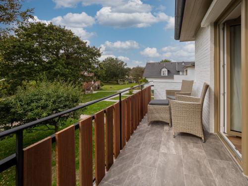 a patio with chairs and a table on a balcony at Aparthotel Friesenhof in Wenningstedt