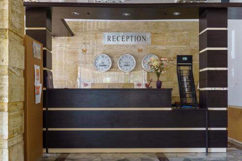 una zona reception in un edificio con orologi appesi al muro di Hotel NAVI a Shabla