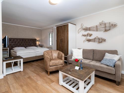 a hotel room with a bed and a couch and a table at Aparthotel Friesenhof in Wenningstedt