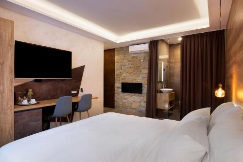 a hotel room with a large white bed and a desk at Štok - Rooms, Wine & Restaurant - Marezige, Koper in Koper