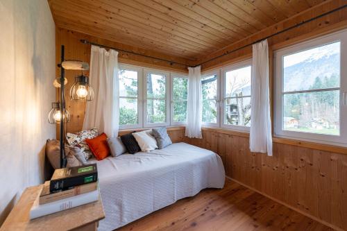 a bedroom with a bed in a room with windows at Das Haus in Altaussee in Altaussee