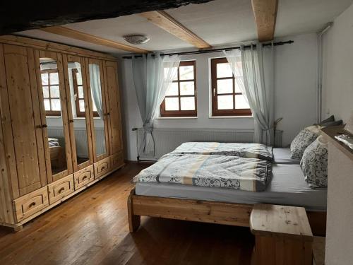 a bedroom with a bed and some windows at Fachwerk in Bergfreiheit in Bad Wildungen