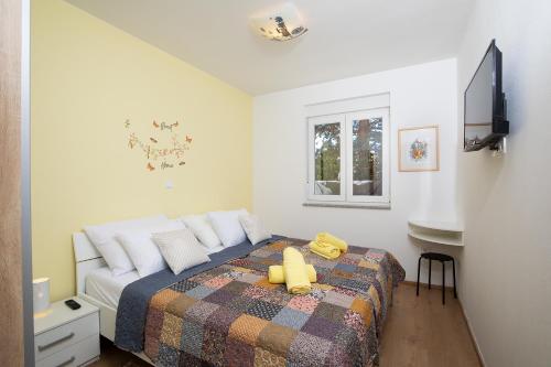 sypialnia z łóżkiem z żółtą kaczką w obiekcie Apartment J&E w Medulinie
