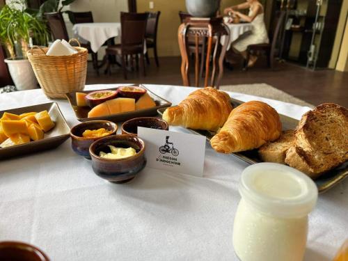 een tafel met een dienblad vol brood, gebak en drankjes bij La Maison d'Indochine in Hội An