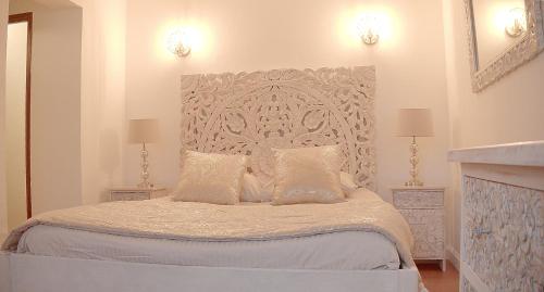 a bedroom with a large bed with white sheets and pillows at Domaine Des Médards in Beaulieu-sur-Loire