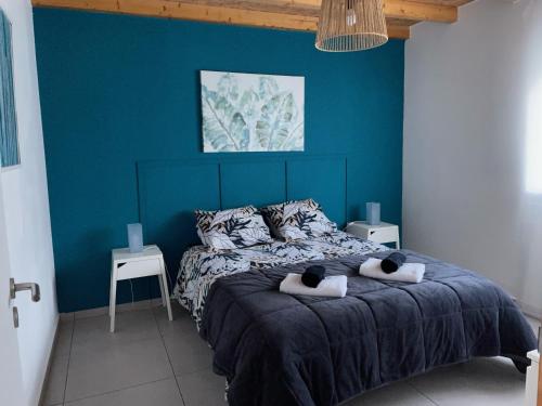 a blue bedroom with a bed with two black cats on towels at Casa São Domingos in Salir de Matos