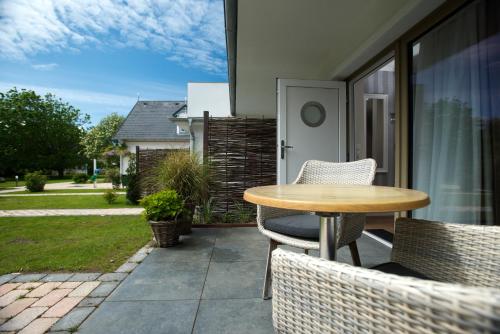 a patio with a table and chairs on a porch at Aparthotel Friesenhof in Wenningstedt