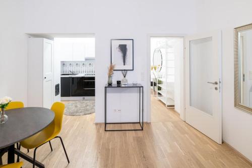 cocina y comedor con mesa y sillas amarillas en Beautiful apartment in Vienna's heart 1b en Viena