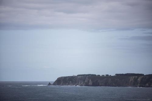 a view of the ocean with a cliff in the distance at La Salina - Complejo Turistico Rural CaleaCabo in Biescas