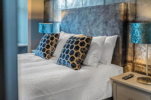 1 dormitorio con 1 cama con almohadas y 2 lámparas en Boutique Modern Royal Mile Apartment Sleeps 4, en Edimburgo