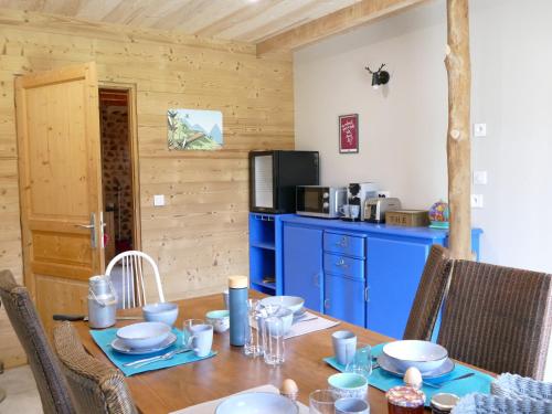 une salle à manger avec une table en bois et une armoire bleue dans l'établissement Chambre d'hôtes à la ferme, à Saint-Michel-de-Maurienne