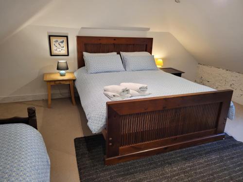 a bedroom with a bed with two towels on it at Ballyrider House Beautiful Triple Suite in Inch Cross Roads