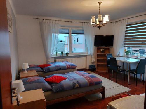 a bedroom with two beds and a dining room with a table at Agroturystyka KAPRYS 2 in Białogard