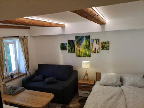 a living room with a blue couch and a bed at City Center Old Town Studio in Innsbruck