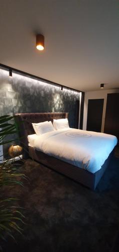 a bedroom with a large bed with white sheets at Contemporary Dublin Suite in Lispapple Cross Roads