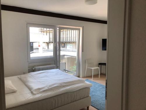 a bedroom with a bed and a large window at City Hotel und City Apartments Centrum in Kaiserslautern