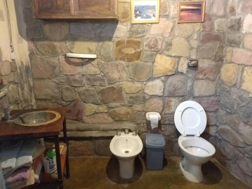 a stone bathroom with a toilet and a sink at La Amarilla, casa con hermosa vista in Tilcara