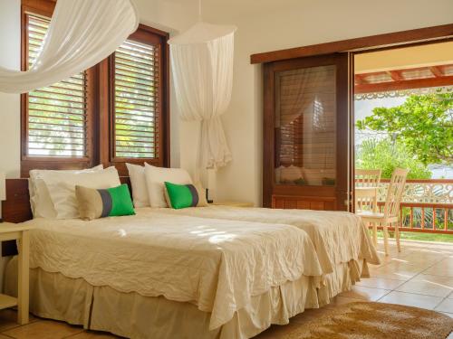 a bedroom with a large bed and a balcony at Gingerbread Suites in Port Elizabeth