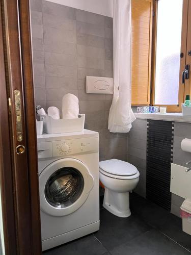 a bathroom with a washing machine and a toilet at Casa Roberto in Cefalù