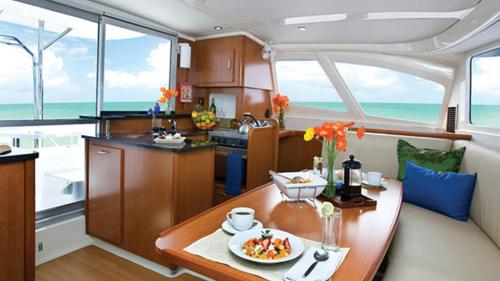 a kitchen and dining room in a yacht at Sabba Whitesand Catamaran in Fodhdhoo
