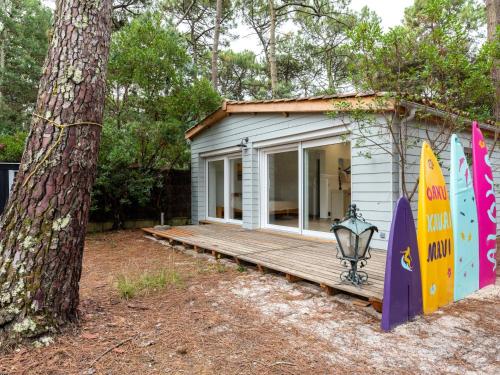 Casa pequeña con porche de madera junto a un árbol en Chalet Cottage Etoile de mer by Interhome, en Lacanau