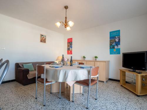 een woonkamer met een tafel met stoelen en een bank bij Apartment Etoile de Mer by Interhome in Canet-en-Roussillon