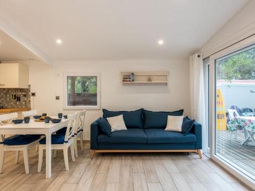 un salon avec un canapé bleu et une table dans l'établissement Chalet Cottage Etoile de mer by Interhome, à Lacanau