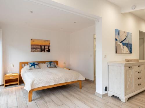 Un dormitorio con una cama y suelo de madera. en Chalet Cottage Etoile de mer by Interhome, en Lacanau