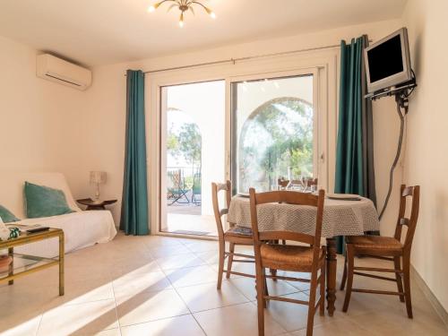 un soggiorno con tavolo e una camera da letto di Apartment Hibiscus by Interhome a Le Rayol-Canadel-sur-Mer