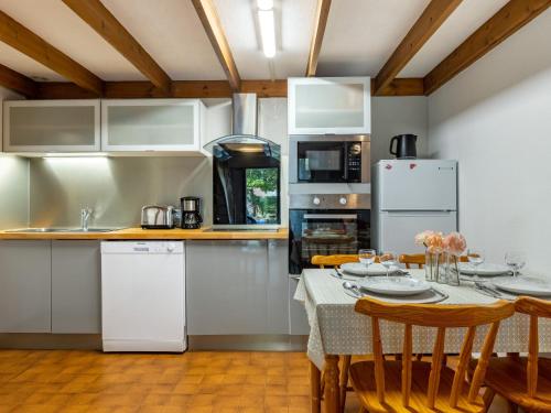 a kitchen with white cabinets and a table with chairs at Holiday Home Les Maisons de l'Océan-1 by Interhome in Les Mathes