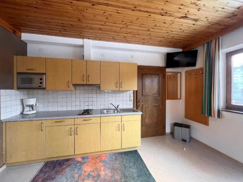 an empty kitchen with wooden cabinets and a window at Apartment App-1 by Interhome in Hollersbach im Pinzgau