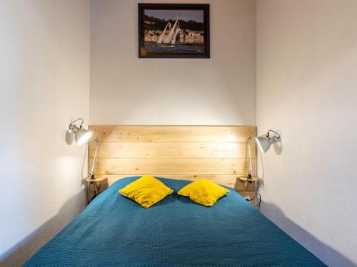 - une chambre avec un lit bleu et 2 oreillers jaunes dans l'établissement Holiday Home Les Maisons de l'Océan-1 by Interhome, aux Mathes