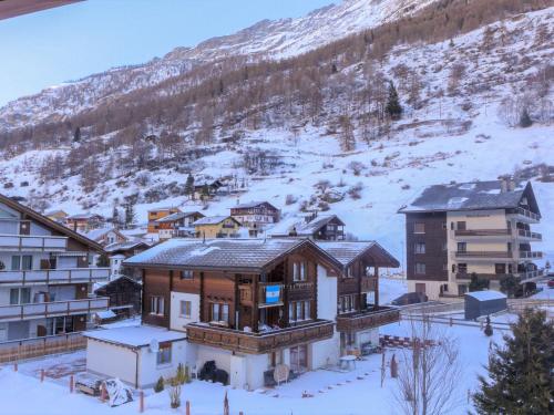 a group of buildings in the snow with a mountain at Apartment Arbgrat by Interhome in Täsch