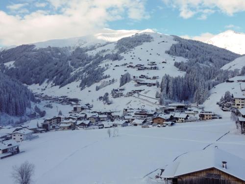 a village covered in snow in front of a mountain at Apartment Wanglblick by Interhome in Tux